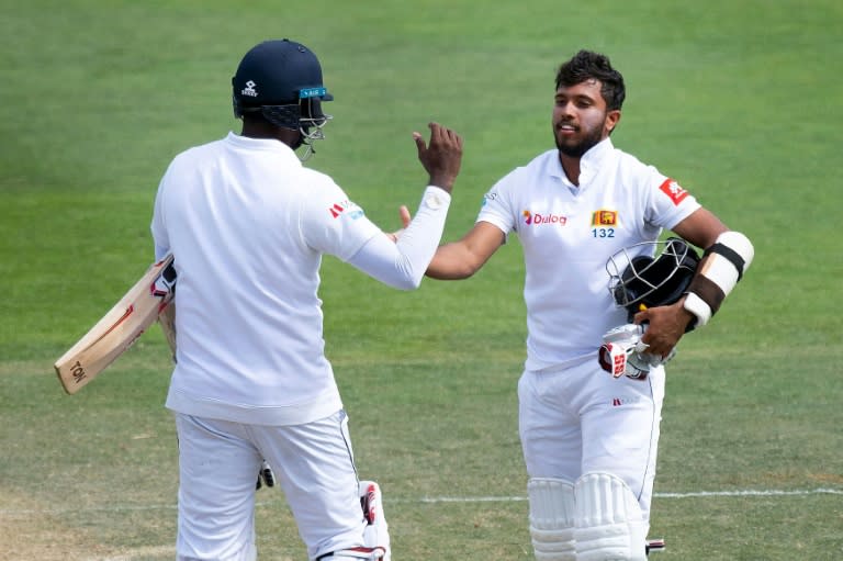 Kusal Mendis (right) celebrates reaching his century during his record unbroken partnership with Angelo Mathews (left)