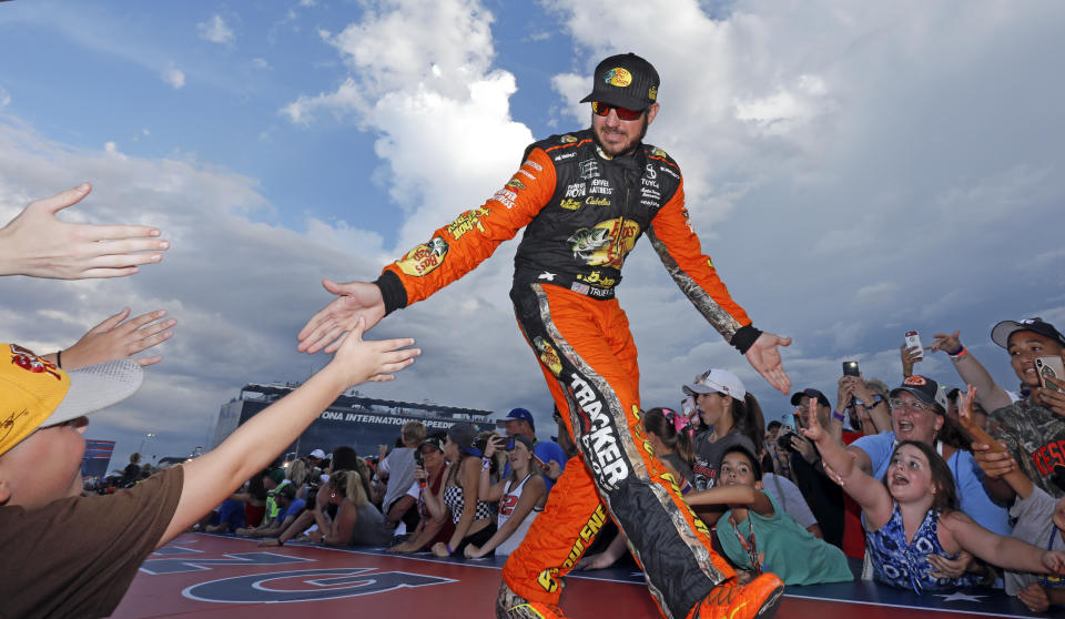 Martin Truex Jr. greets fans before the NASCAR Cup Series auto race at Daytona International Speedway, Saturday, July 7, 2018, in Daytona Beach, Fla. (AP Photo/Terry Renna)