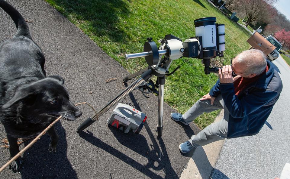 Chris Davis sets up a telescope in his driveway to view the sun.