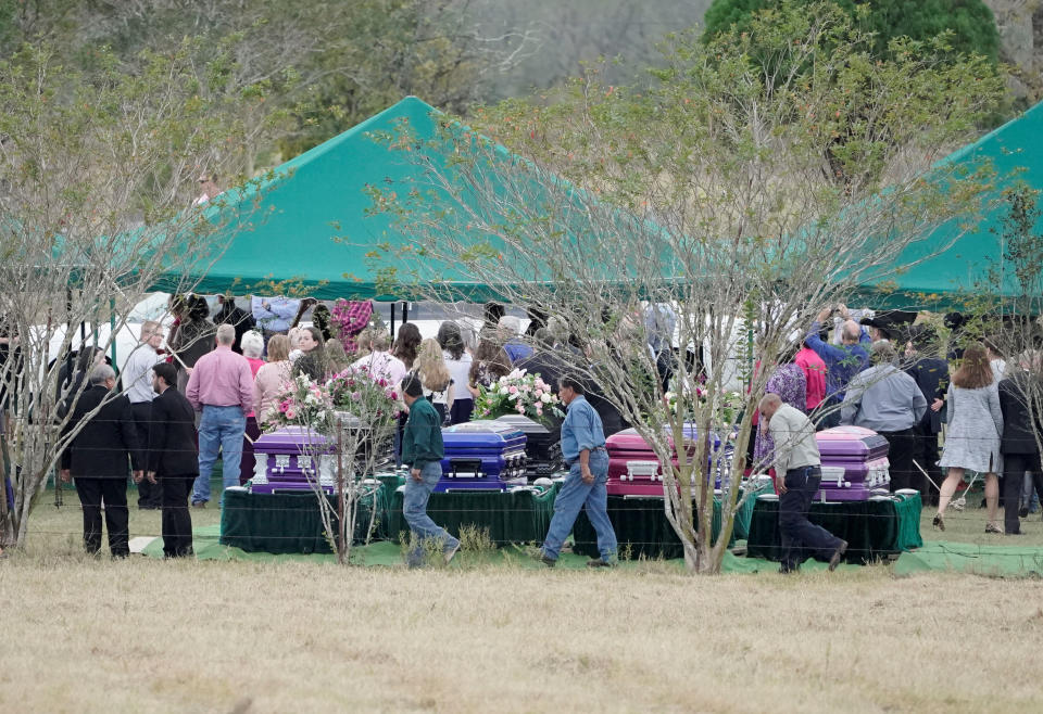 Mourners walk past caskets containing the bodies of members of the Holcombe and Hill families, victims of the Sutherland Springs Baptist church shooting, during a graveside service in Sutherland Springs, Texas, on Nov. 15 (Photo: Darren Abate / Reuters)