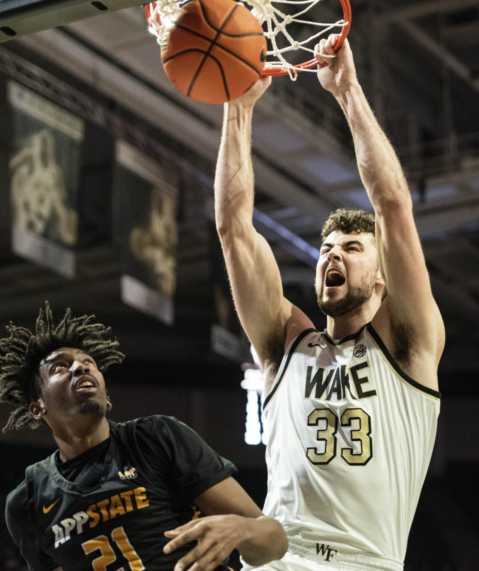 Wake Forest forward Matthew Marsh (33) dunks over Appalachian State forward Justin Abson (21) in the first half of an NCAA college basketball game on Wednesday, Dec. 14, 2022, at Joel Coliseum in Winston-Salem, N.C. (Allison Lee Isley/The Winston-Salem Journal via AP)