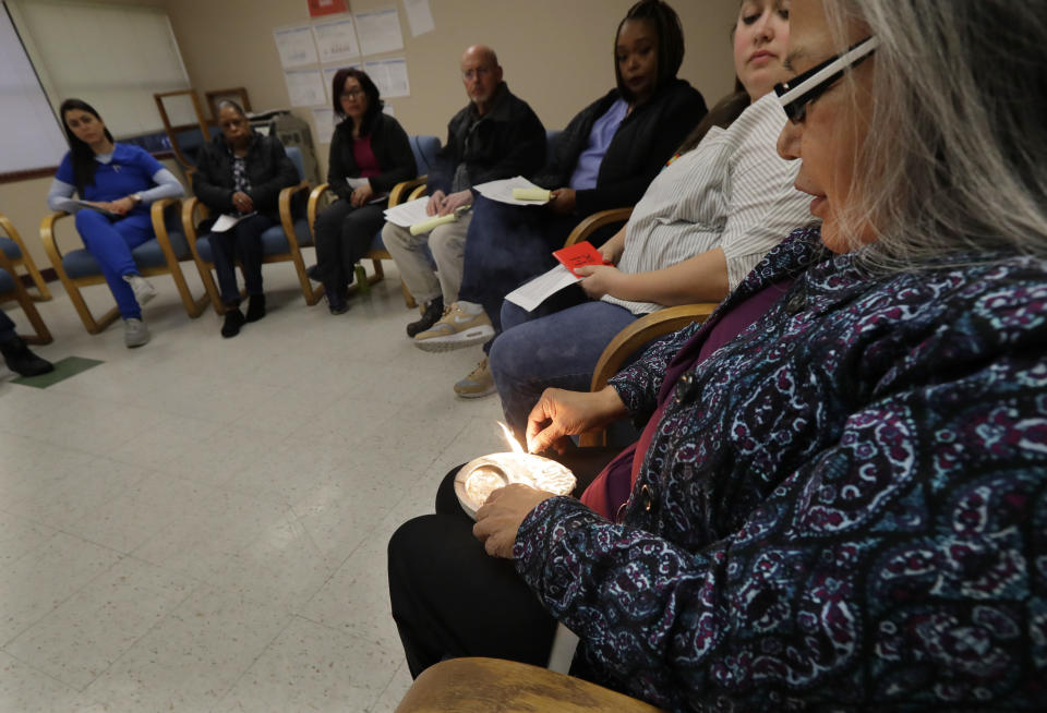 Annette Squetimkin-Anquoe, right, a member of the Colville Indian tribe and the Chief Traditional Health Officer at the Urban Indian Health Institute in Seattle, burns sage in an abalone shell, Friday, Jan. 11, 2019, during a talking circle meeting to discuss the practice of traditional Indian medicine, including blessings and smudging, with employees of the Seattle Indian Health Board. Fallout from the federal government shutdown is hurting hundreds of Native American tribes and entities that serve them. The pain is especially deep in tribal communities with high rates of poverty and unemployment, and where one person often supports an extended family. (AP Photo/Ted S. Warren)