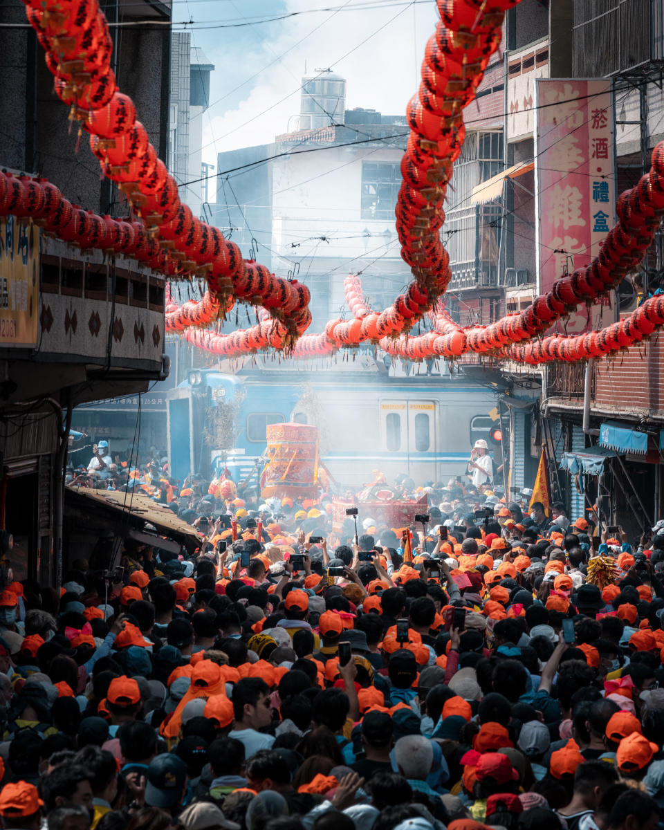 街道擠滿跟隨隊伍的信眾，攝影師拍下媽祖等待列車駛離的瞬間。（圖／攝影師Hzy.s授權提供）