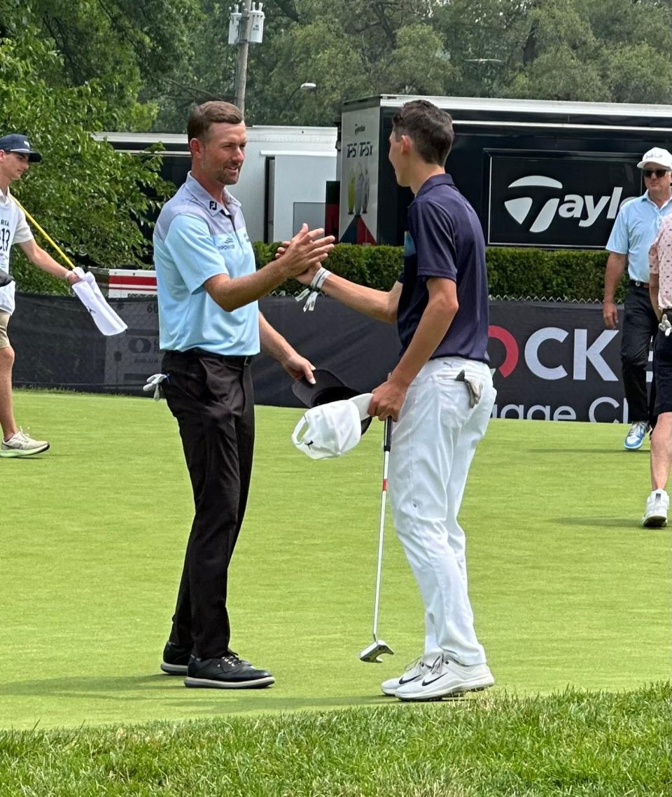 Port Huron Northern's Luke Maher (right) celebrates with Webb Simpson during the pro-am of the Rocket Mortgage Classic at Detroit Golf Club on Wednesday. Maher and Simpson were on the same team.