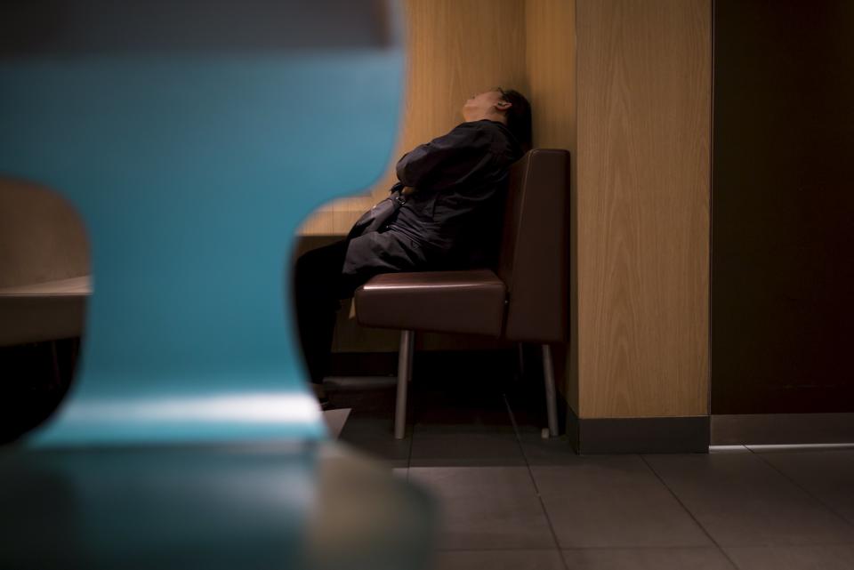 A man sleeps at a 24-hour McDonald's restaurant in Hong Kong, China