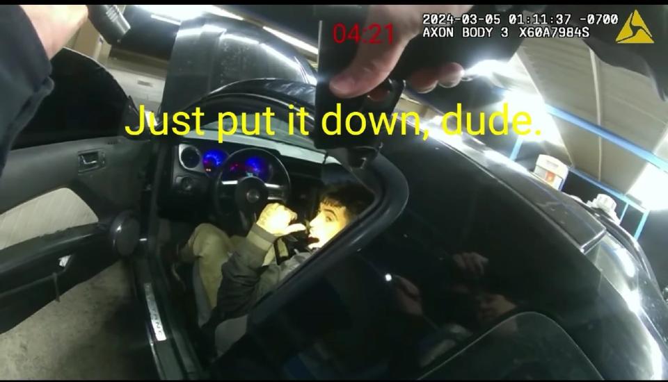 An El Paso police officer tells Michael Estrada, who says he has a gun, "Just put it down, dude," in a screenshot of a body camera video released by the El Paso Police Department on March 23 showing Estrada's fatal shooting at a car wash on March 5, 2024.