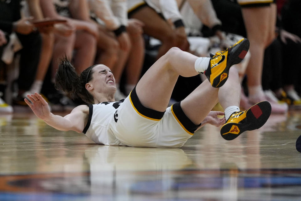 Iowa guard Caitlin Clark falls to the court during the second half of a Final Four college basketball game against UConn in the women's NCAA Tournament, Friday, April 5, 2024, in Cleveland. (AP Photo/Carolyn Kaster)