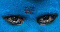 A boy dressed as Lord Shiva, the Hindu god of destruction and regeneration, looks on as he begs for alms on the banks of river Ganges in Allahabad, India, Sunday, Sept. 20, 2009. (AP Photo/Rajesh Kumar Singh)