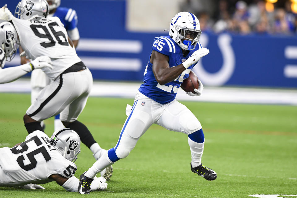 Indianapolis Colts running back Marlon Mack (25) breaks way from Oakland Raiders outside linebacker Vontaze Burfict (55) during the first half of an NFL football game in Indianapolis, Sunday, Sept. 29, 2019. (AP Photo/Doug McSchooler)