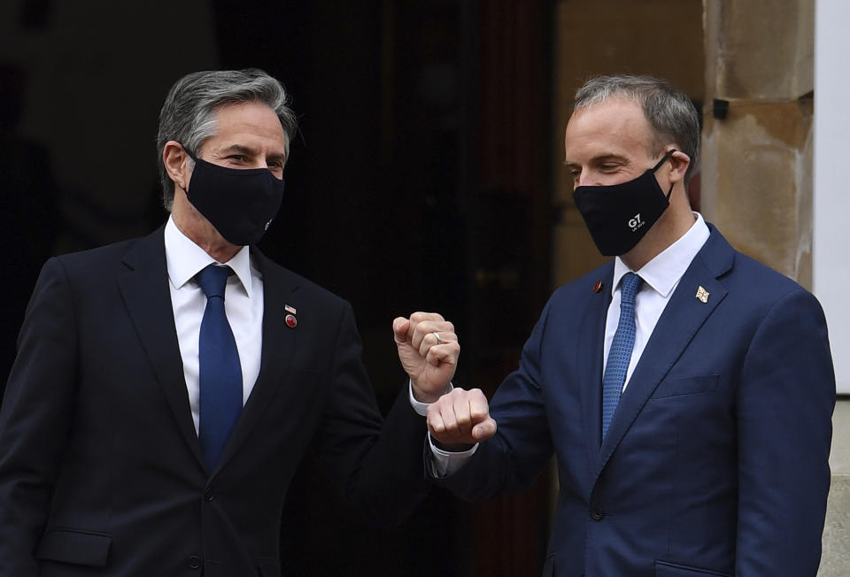 Wearing face masks bearing the G7 logo, US Secretary of State Antony Blinken, left, is greeted by Britain's Foreign Secretary Dominic Raab at the start of the G7 foreign ministers meeting in London Tuesday May 4, 2021. G7 foreign ministers meet in London Tuesday for their first face-to-face talks in more than two years. (Ben Stansall / Pool via AP)