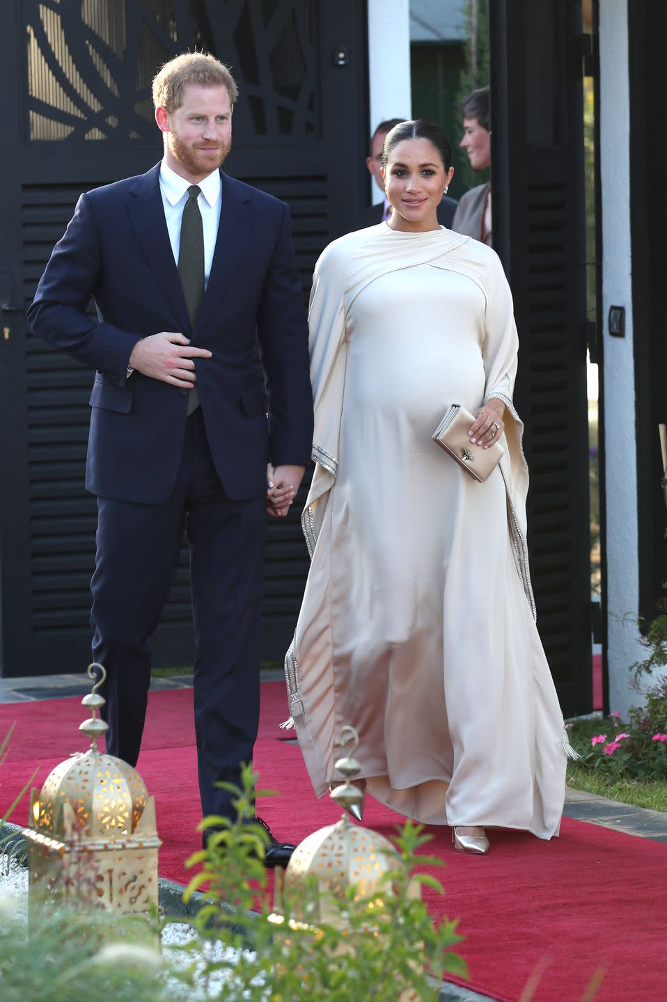 <p>Meghan arrived at the British Ambassador residence wearing a gorgeous bespoke Dior gown. She paired the look with <a href="https://www.maisonbirks.com/en/birks-snowflake-snowstorm-diamond-earrings-in-white-gold" rel="nofollow noopener" target="_blank" data-ylk="slk:diamond earrings by Maison Birks;elm:context_link;itc:0;sec:content-canvas" class="link ">diamond earrings by Maison Birks</a>, which she <a href="https://www.townandcountrymag.com/style/fashion-trends/a24183870/meghan-markle-white-theia-gown-dinner-tonga-photo/" rel="nofollow noopener" target="_blank" data-ylk="slk:wore on her Oceanic tour;elm:context_link;itc:0;sec:content-canvas" class="link ">wore on her Oceanic tour</a>, <a href="https://go.redirectingat.com?id=74968X1596630&url=https%3A%2F%2Fus.vestiairecollective.com%2Fwomen-bags%2Fdior%2Fd-bee%2F&sref=https%3A%2F%2Fwww.townandcountrymag.com%2Fstyle%2Ffashion-trends%2Fg3272%2Fmeghan-markle-preppy-style%2F" rel="nofollow noopener" target="_blank" data-ylk="slk:a satin clutch;elm:context_link;itc:0;sec:content-canvas" class="link ">a satin clutch</a> and gold pumps, both by Dior. </p>