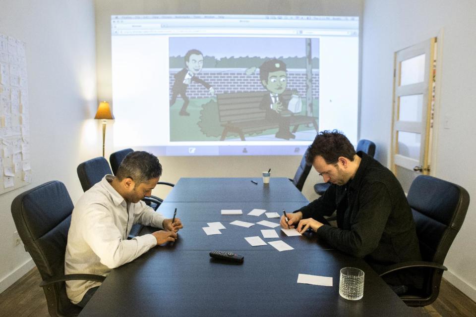 In this Dec. 19, 2013 photo, Bitstrips CEO and Creative Director Jacob Blackstock, right, and co-founder Shahan Panth draw cartoons as part of a brain storming process at the company's offices in Toronto. Bitstrips, a mobile application that helps people turn their lives into comic strips, may seem like a sudden sensation now that its vignettes are all over Facebook and other social networks. But the Toronto startup’s success has been a drawn-out process. (AP Photo/The Canadian Press, Chris Young)