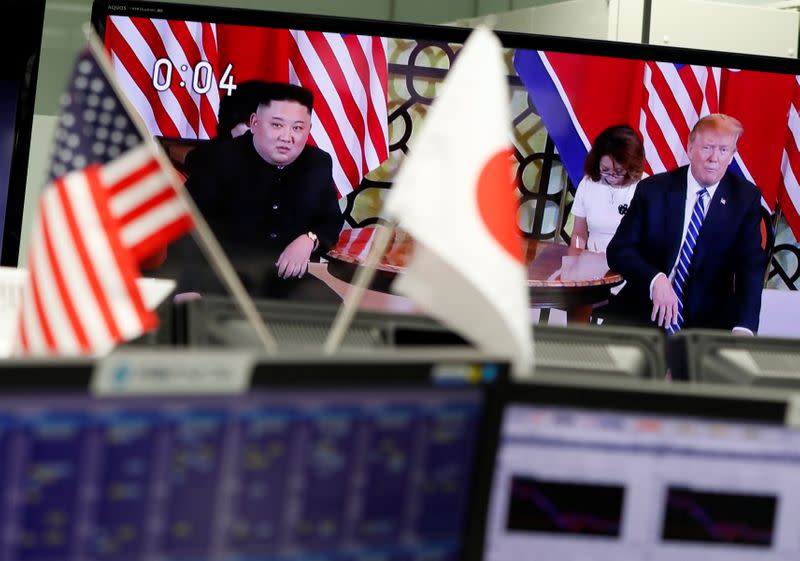 FILE PHOTO: A television monitors broadcasting a meeting between U.S. President Donald Trump and North Korean leader Kim Jong Un during their second North Korea-U.S. summit in Hanoi, is seen through Japan and the U.S. national flags in Tokyo