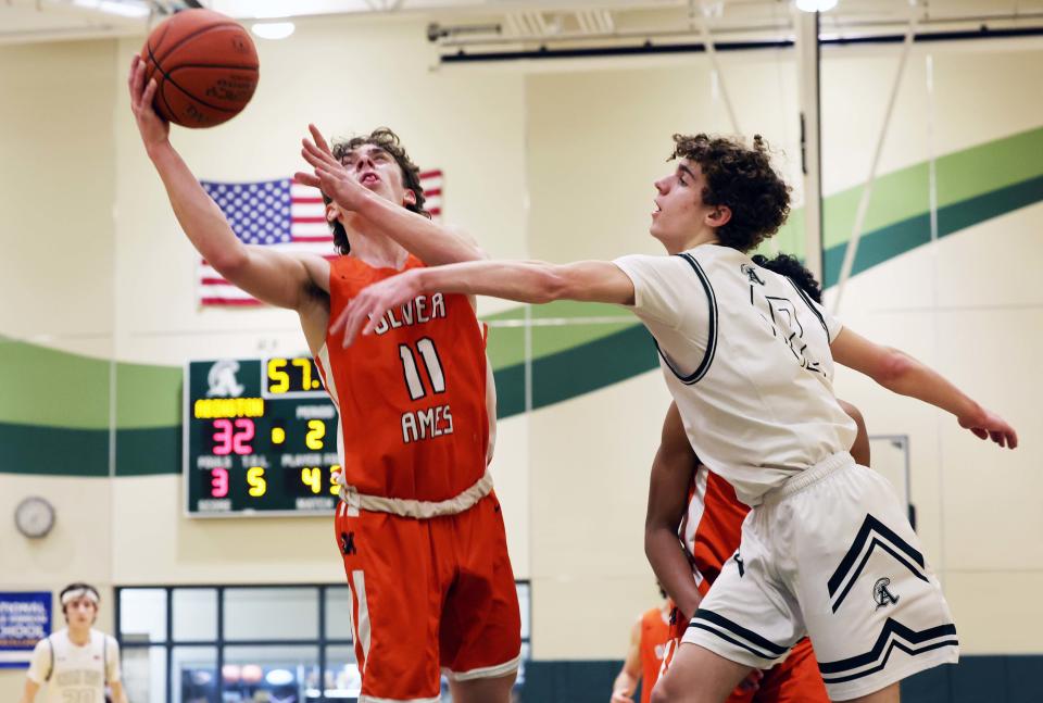 Oliver Ames Jake Willard scores a basket on Abington defender Hunter Maxwell during the Don Byron memorial game on Wednesday, Feb. 15, 2023.