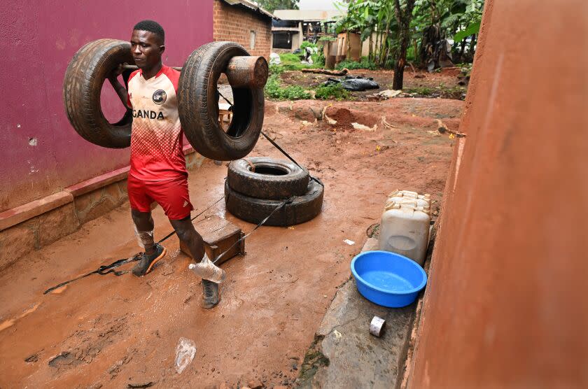 Gayaza, Uganda Abril de 2023: Dennis Kazumba hace ejercicio con neumáticos viejos frente a su casa en Guyaza, Uganda.