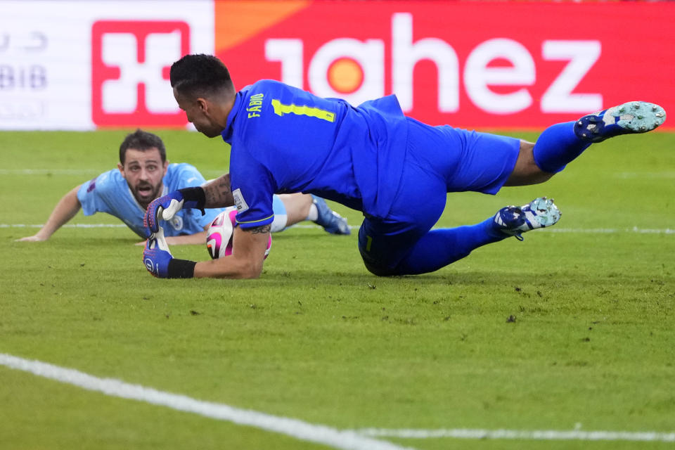 Fluminense goalkeeper Fabio makes a save in front of Manchester City's Bernardo Silva during the Soccer Club World Cup final match between Manchester City FC and Fluminense FC at King Abdullah Sports City Stadium in Jeddah, Saudi Arabia, Friday, Dec. 22, 2023. (AP Photo/Manu Fernandez)