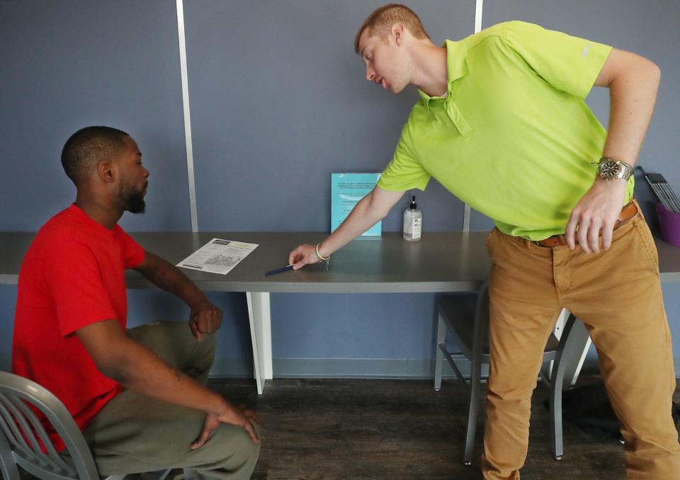 Roger Dixon, 33 listens to Bradley Zimmerman, staffing supervisor at GreatWork Employment as get gets ready to fill out paper work for a job in Akron on Wednesday June 9, 2021. Dixson, was the only one of four scheduled appointments to show up at the agency.