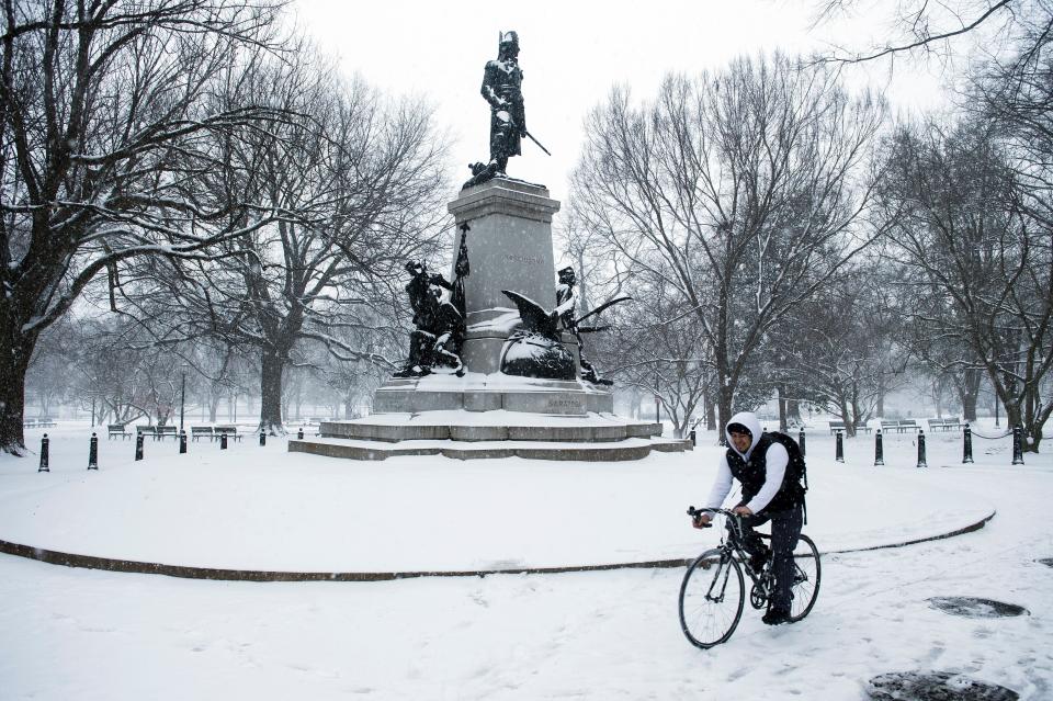 A biker crosses a monument in Lafayette Park during a snow storm in Washington on January 22, 2016. Thousands of flights were cancelled and supermarket shelves were left bare Friday as millions of Americans hunkered down for a winter storm expected to dump historic amounts of snow in the eastern United States.