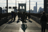 Pedestrians walk on the Brooklyn Bridge in New York, Wednesday, Jan. 3, 2024. New York City has banned vendors from the Brooklyn Bridge starting Wednesday. The move is intended to ease overcrowding on the famed East River crossing, where dozens of souvenir sellers competed for space with tourists and city commuters. (AP Photo/Seth Wenig)