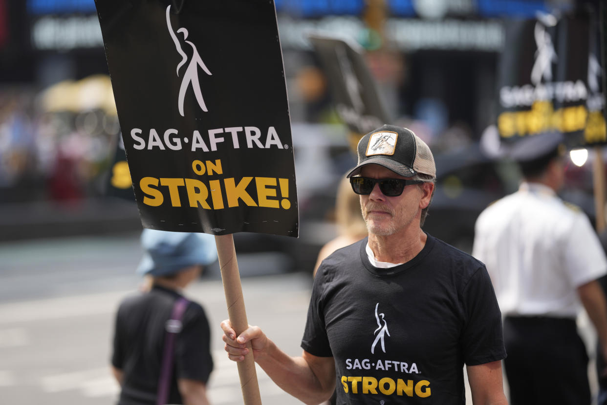 Actor Kevin Bacon carries a sign on a picket line outside Paramount in Times Square on Monday, July 17, 2023, in New York. The actors strike comes more than two months after screenwriters began striking in their bid to get better pay and working conditions and have clear guidelines around the use of AI in film and television productions. (Photo by Charles Sykes/Invision/AP)