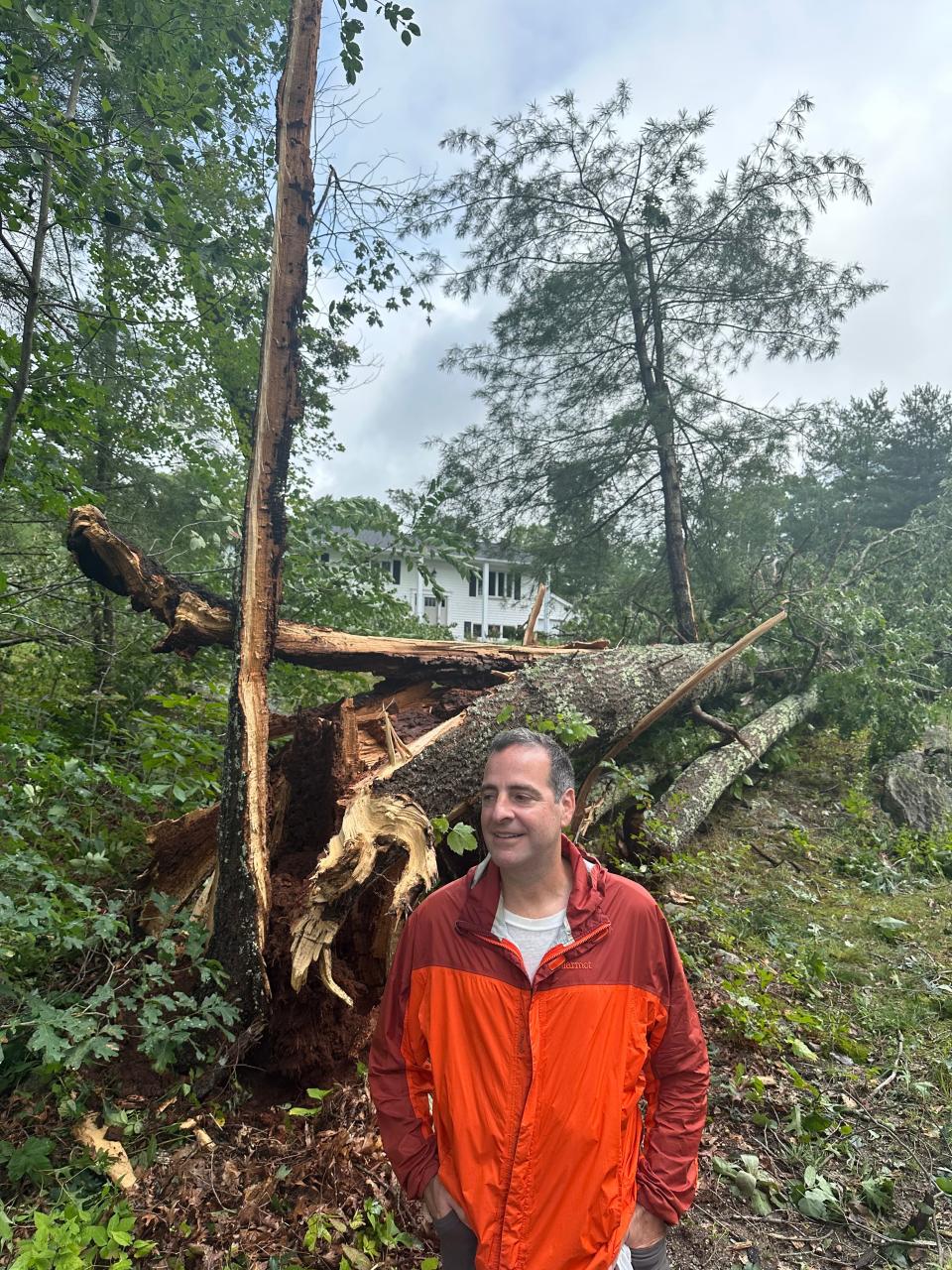 John Gostanian of Byron Randall Road in Scituate, Rhode Island, in front of a tree that went down in his neighborhood during a suspected tornado on Aug. 18, 2023