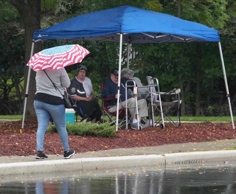 Parade fans try to stay dry from the rain as they wait for the start of the 103rd annual Sussex County Firemen's Parade in Hopatcong on Saturday, Oct. 7, 2023.