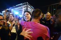 Syriza MP Zoe Kostantopoulou embraces a 'No' supporter as she joins the celebrations in front of parliament in Athens