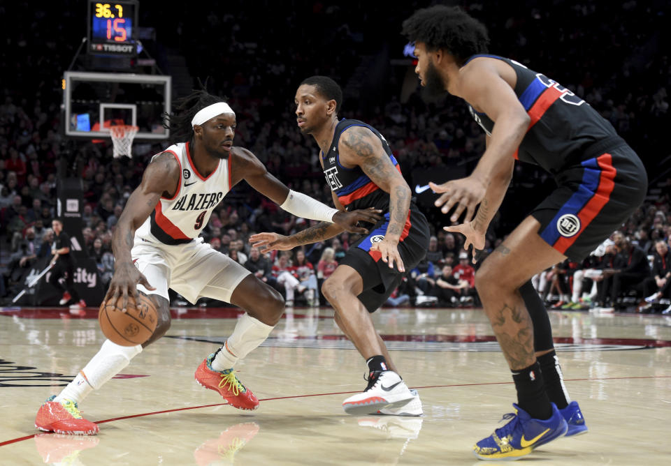 Portland Trail Blazers forward Jerami Grant, left, looks to drive to the basket against Detroit Pistons guard Rodney McGruder, center, and forward Marvin Bagley III, right, during the first half of an NBA basketball game in Portland, Ore., Monday, Jan. 2, 2023. (AP Photo/Steve Dykes)