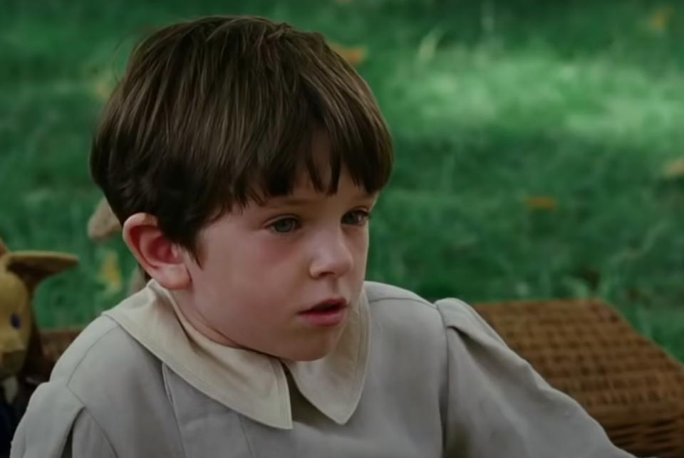 Freddie Highmore as Peter sits on the grass during a scene from "Finding Neverland"