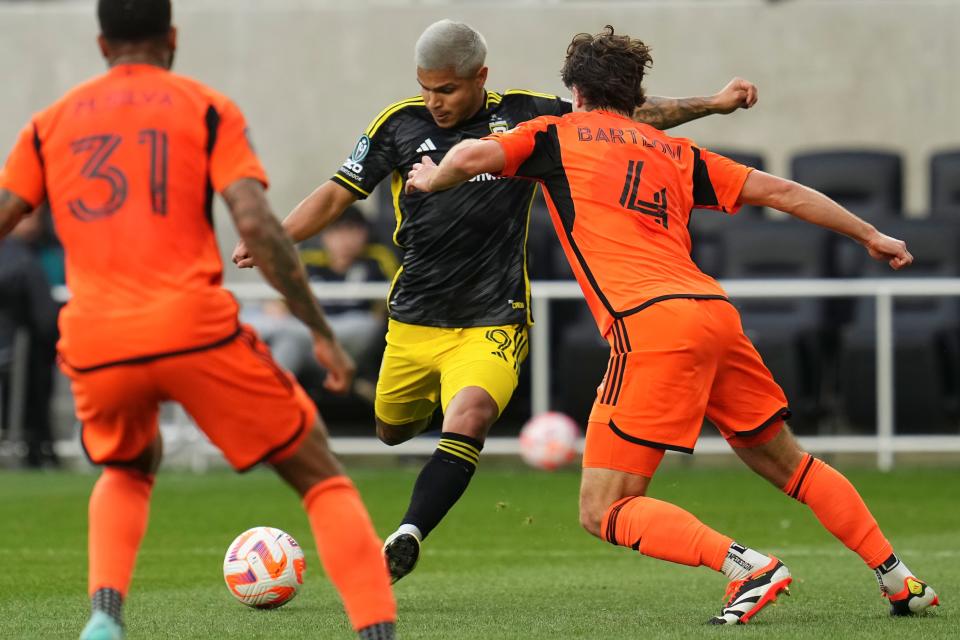 Mar 12, 2024; Columbus, OH, USA; Columbus Crew forward Cucho Hernandez (9) scores a goal past Houston Dynamo defender Ethan Bartlow (4) and defender Micael (31) during the first half of the Concacaf Champions Cup soccer game at Lower.com Field. Mandatory Credit: Adam Cairns-USA TODAY Sports