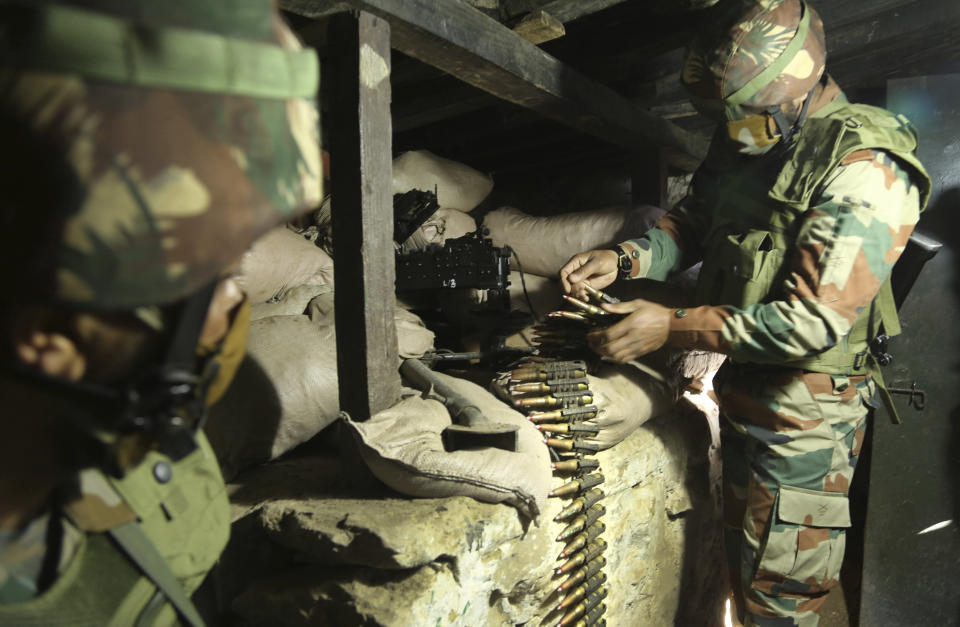 FILE - In this Dec. 18, 2020, file photo, Indian army soldiers prepare a light machine gun in their bunker at a forward post along the Line of Control (LOC) between India and Pakistan border in Poonch, about 250 kilometers (156 miles) from Jammu, India. The Line of Control, a highly militarized de facto border that divides the disputed region between the two nuclear-armed rivals India and Pakistan, and a site of hundreds of deaths, is unusually quiet after the two South Asian neighbors agreed in February, 2021, to reaffirm their 2003 cease-fire accord. (AP Photo/Channi Anand, File)