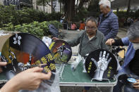 Hong Kong men prepare protest themed clocks made from vinyl records ahead of a rally demanding electoral democracy and call for boycott of the Chinese Communist Party and all businesses seen to support it in Hong Kong, Sunday, Jan. 19, 2020. Hong Kong has been wracked by often violent anti-government protests since June, although they have diminished considerably in scale following a landslide win by opposition candidates in races for district councilors late last year. (AP Photo/Ng Han Guan)