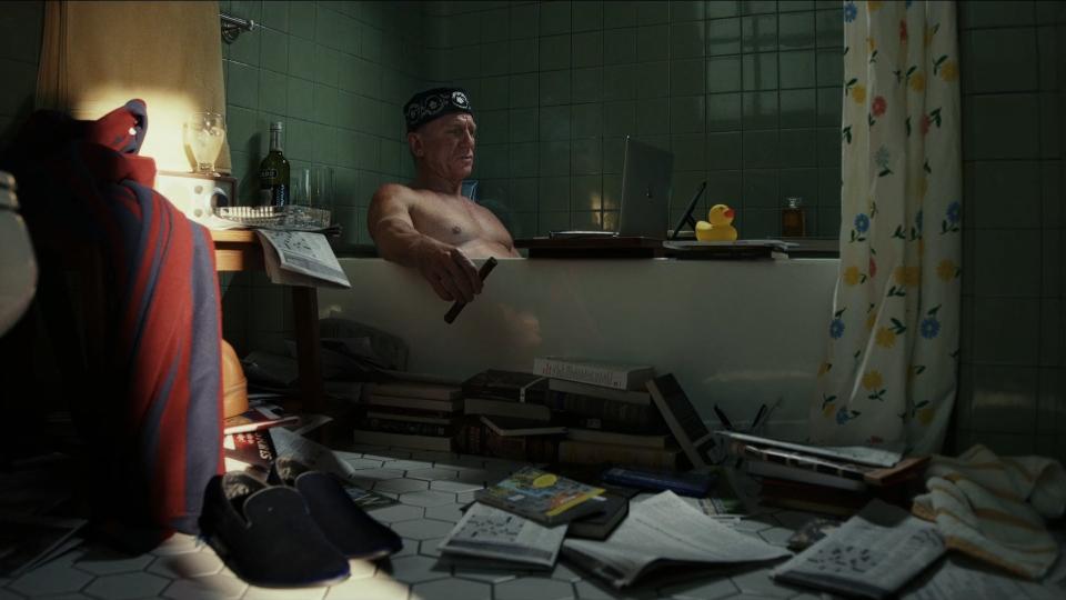 Daniel Craig smokes a cigar while sitting in his bathtub
