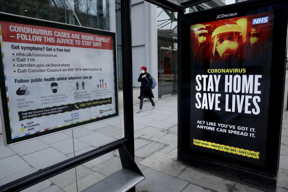 Coronavirus information signs are displayed in a bus stop in London, Friday, Jan. 15, 2021, during England's third national lockdown since the coronavirus outbreak began. The U.K. is under an indefinite national lockdown to curb the spread of the new variant, with nonessential shops, gyms and hairdressers closed, most people working from home and schools largely offering remote learning. (AP Photo/Matt Dunham)