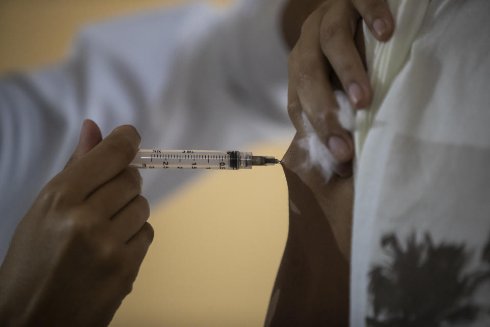 A man gets a shot of the AstraZeneca vaccine for COVID-19 during a vaccination campaign for people over age 35 in Rio de Janeiro, Brazil, Friday, July 23, 2021. (AP Photo/Bruna Prado)