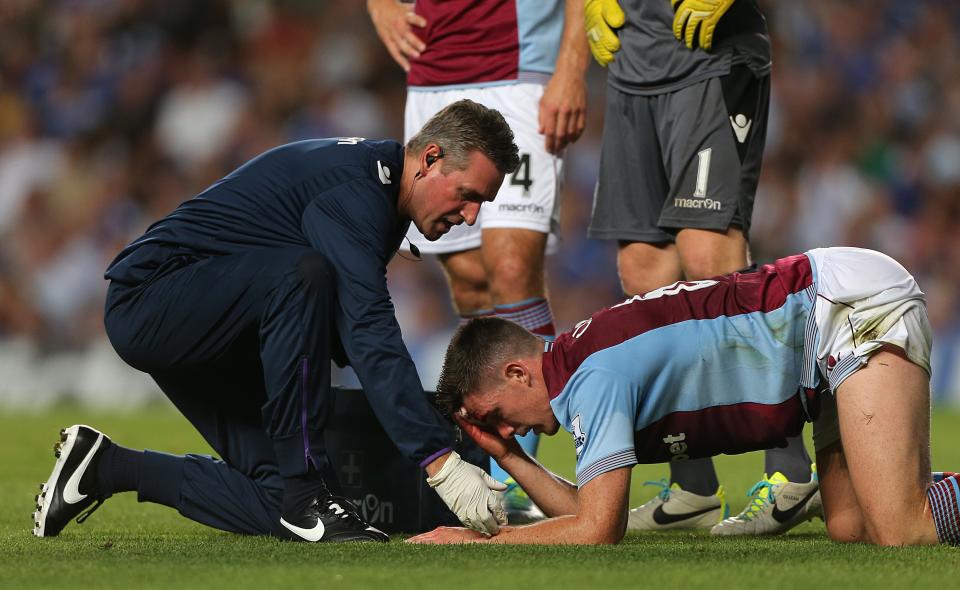 Aston Villa's Ciaran Clark is treated for a head injury 