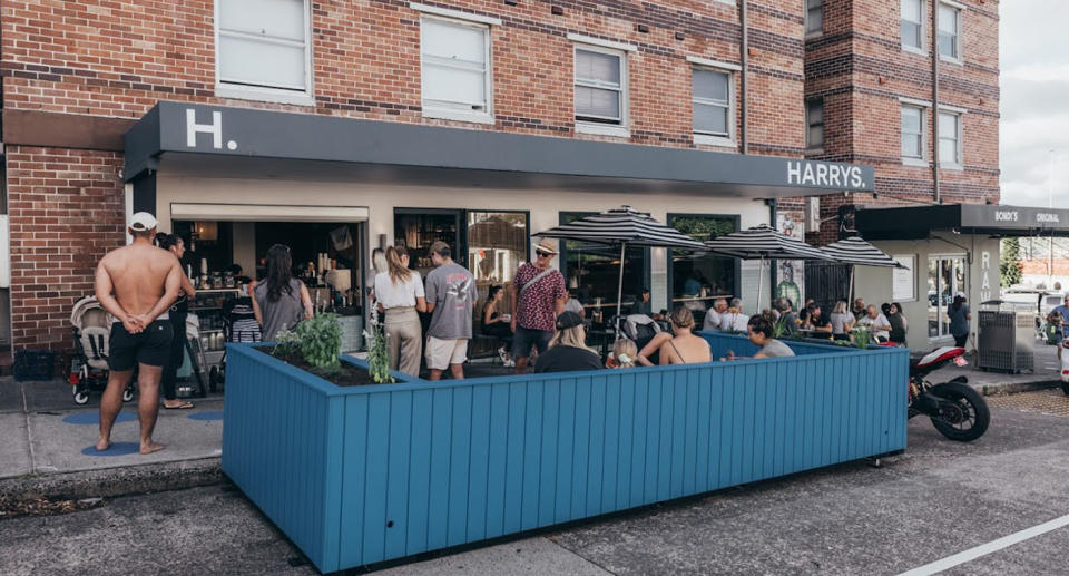 People sitting and eating outside at Harry's cafe Bondi. 