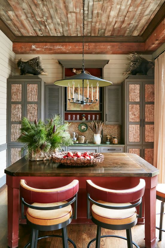 revelry in the pines richard keith langham's rural mississippi hunting lodge the kitchen with wrought iron chandelier currey company lights a maple topped island and suede swivel counter stools louis j solomon
