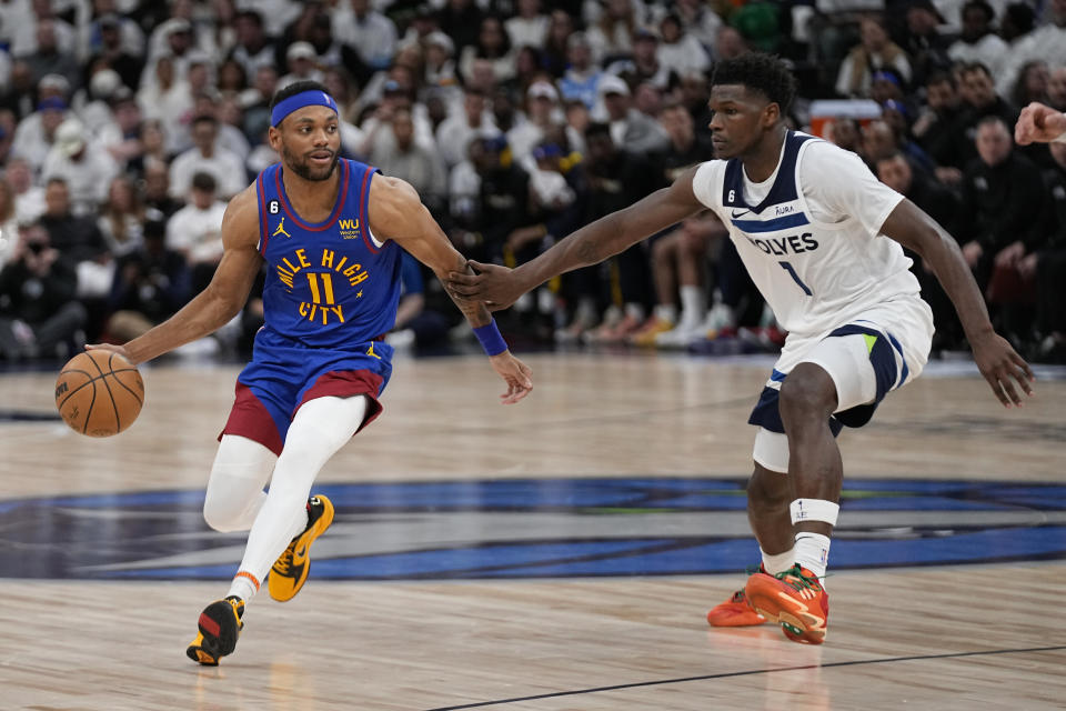 Denver Nuggets forward Bruce Brown (11) drives against Minnesota Timberwolves guard Anthony Edwards (1) during the second half of Game 3 of an NBA basketball first-round playoff series Friday, April 21, 2023, in Minneapolis. (AP Photo/Abbie Parr)