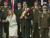 VIDEO STILL, BEST QUALITY AVAILABLE - In this still from a video provided by Venezolana de Television, Presiden Nicolas Maduro, center, delivers his speech as his wife Cilia Flores winces and looks up after being startled by and explosion, in Caracas, Venezuela, Saturday, Aug. 4, 2018. Venezuela's government says several explosions heard at a military event were an attempted attack on President Maduro. Information Minister Jorge Rodriguez said in a live broadcast that several drone-like devices with explosives detonated near the president. He said Maduro is safe and unharmed but that seven people were injured. (Venezolana de Television via AP)