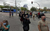 People attend a protest against the handling of the coronavirus pandemic in Madrid, Spain, Sunday, Sept. 20, 2020. Spaniards are protesting in Madrid against the handling of the coronavirus pandemic by the regional head of the Spanish capital, who has placed new restrictions on neighborhoods with the highest contagion rates. The Spanish capital's rate of transmission is more than double the national average, which already leads European contagion charts. The sign reads in Spanish "enough!" (David Obach/Europa Press via AP)