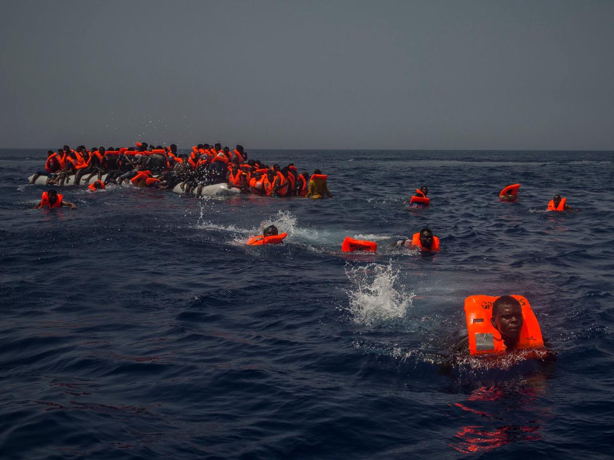African migrants try to reach a rescue boat from the Spanish aid organisation Proactive Open Arms after falling from a punctured rubber boat in the Mediterranean about 12 miles north of Sabratha, Libya (AP )