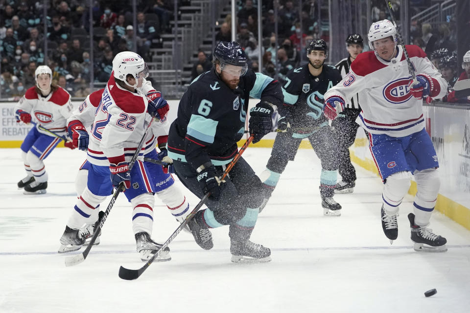 Seattle Kraken defenseman Adam Larsson (6) tries to move the puck against Montreal Canadiens right wing Tyler Toffoli (73), right, and right wing Cole Caufield (22) during the second period of an NHL hockey game, Tuesday, Oct. 26, 2021, in Seattle. (AP Photo/Ted S. Warren)