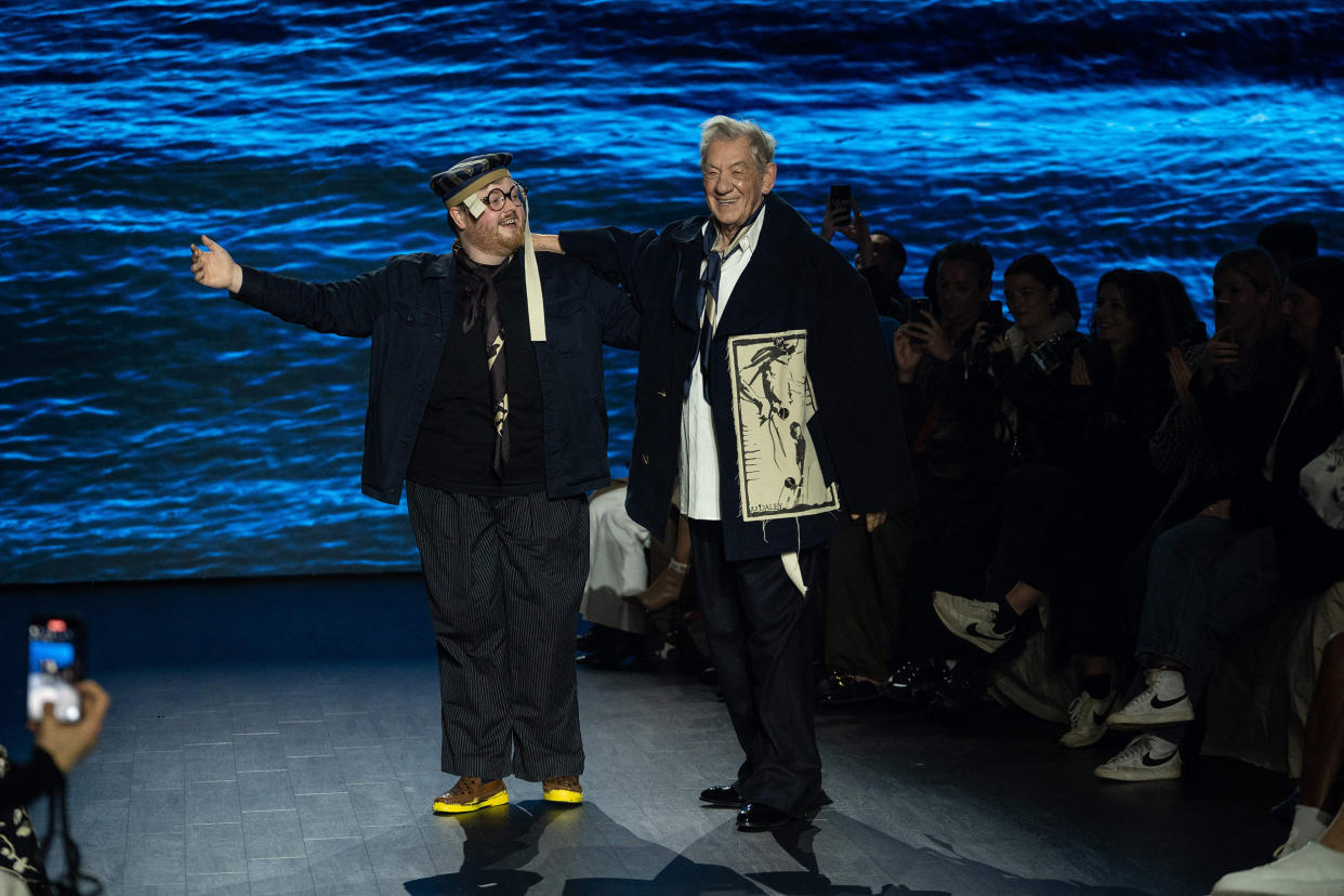 British fashion designer Steven Stokey-Daley (L) and British actor Ian McKellen acknowledge the crowd after Stokey-Daley presented his attends fashion label S.S.Daley's Autumn/Winter 2023 collection catwalk show on the third day of the London Fashion Week, in London, on February 19, 2023. (Niklas Halle'n / AFP via Getty Images)