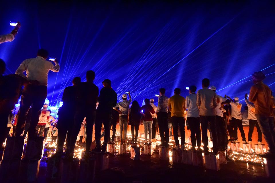 People watch a light show on the banks of river Sarayu on the eve of Diwali, the Hindu festival of lights, in Ayodhya on Oct. 23, 2022.