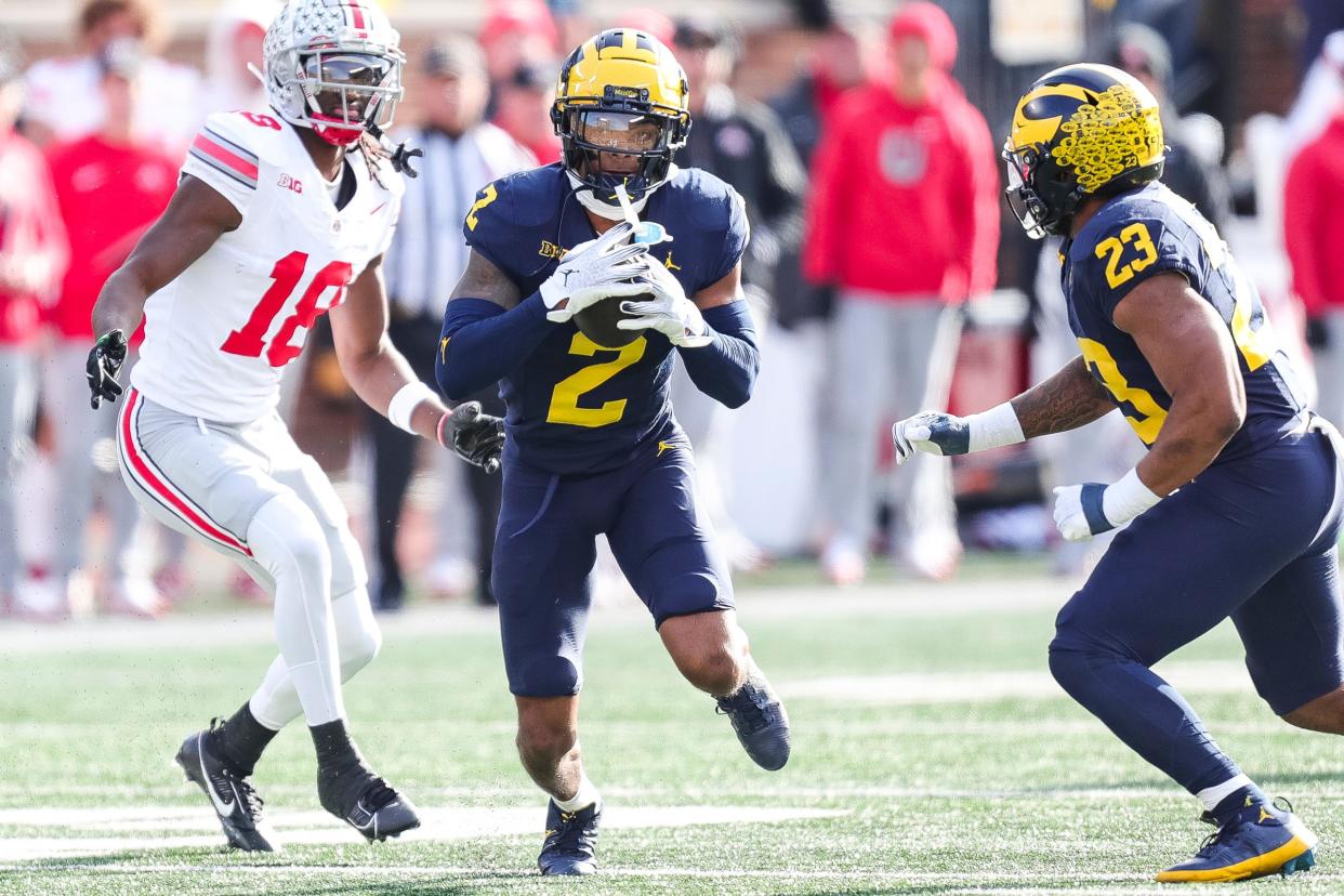 Michigan defensive back Will Johnson intercepts a pass intended for Ohio State wide receiver Marvin Harrison Jr. during the first half at Michigan Stadium in Ann Arbor on Saturday, Nov. 25, 2023.