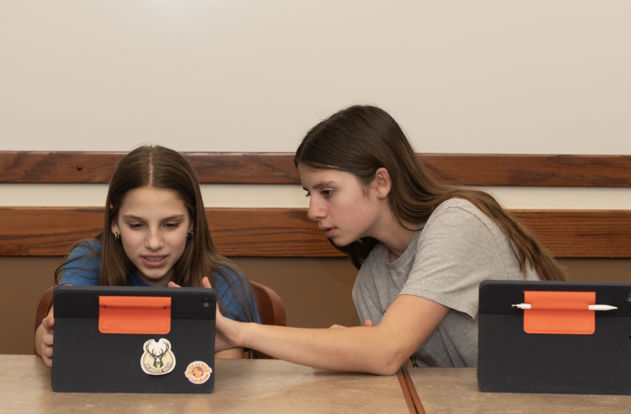 Lila Paynter,12, and Marissa Mallas, 11, help each other out during the coding class.