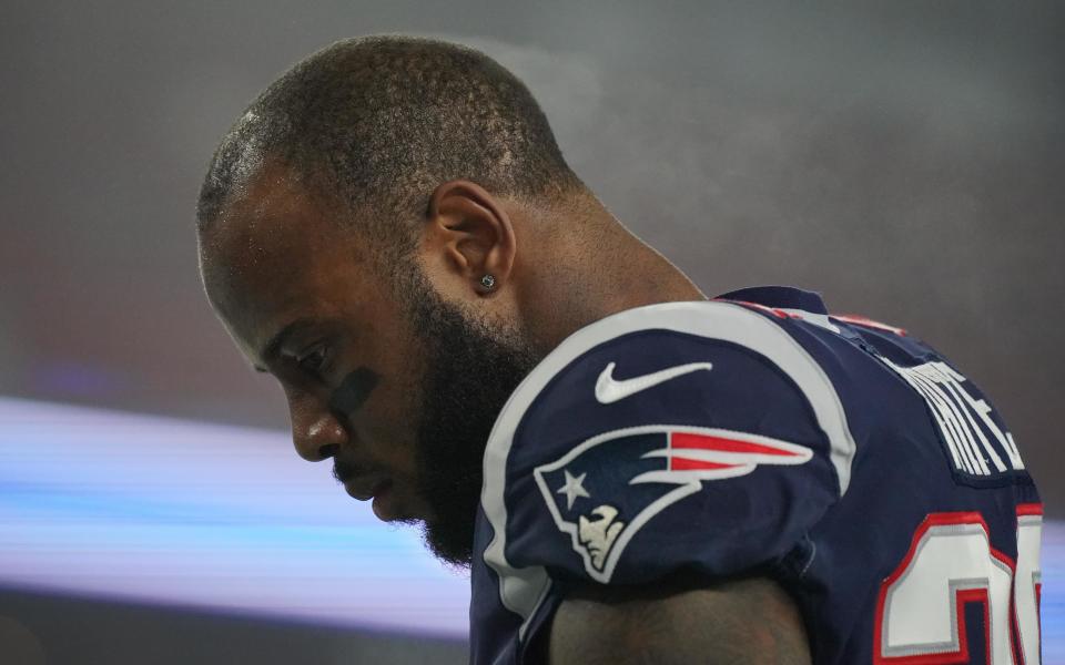 James White bows his head before an NFL game.