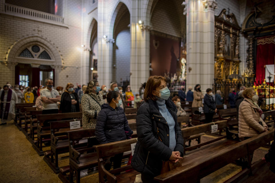 People wearing face masks to protect against the spread of coronavirus attend a mass at Santa Cruz church in downtown Madrid, Spain, Wednesday, March 31, 2021. Spain is bracing for another potential sharp increase in coronavirus cases. And with the vaccine rollout being outpaced by the new more contagious variant of the virus, authorities are asking for citizens to intensify their precautions to "buy time" for the shots to arrive. (AP Photo/Manu Fernandez)