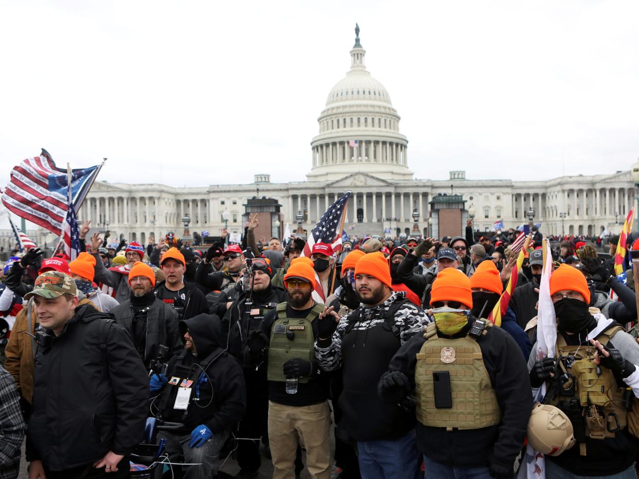 <p>Members of the far-right group Proud Boys make 'OK' hand gestures indicating 